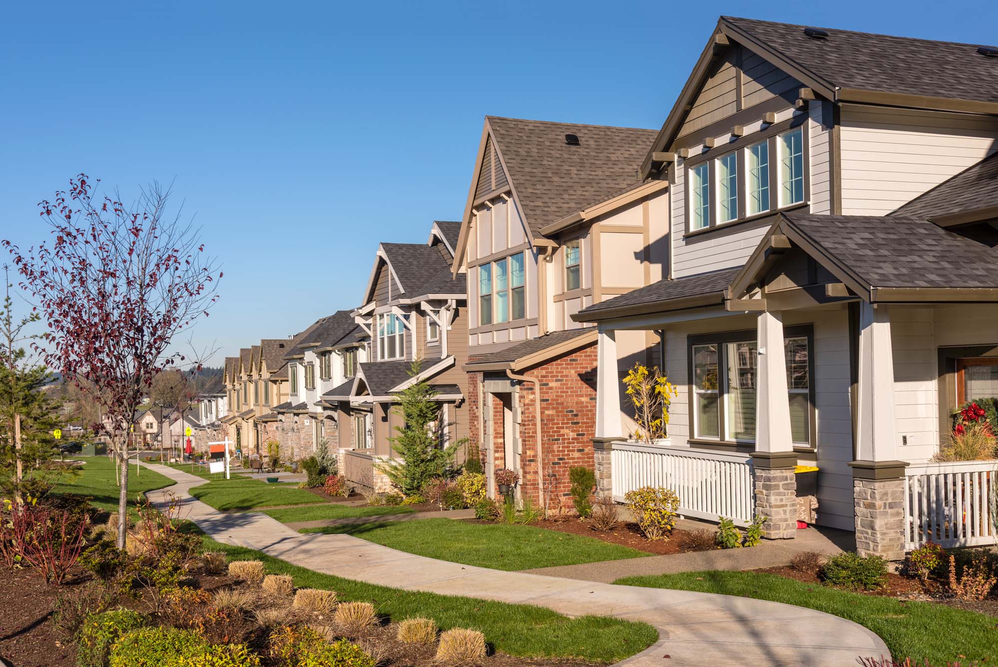 A row of homes with new roofs and exteriors in a neighborhood